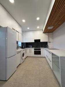 a kitchen with white cabinets and a washer and dryer at Mickey central 2 hostel in Ulaanbaatar +29 photos
