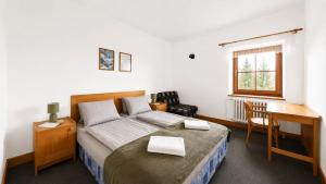 a bedroom with a bed and a desk and a desk at Rennerka Horská bouda in Strážné