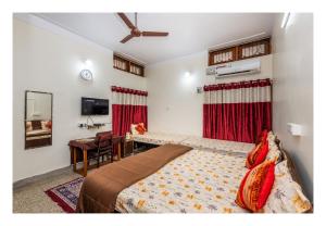 a bedroom with a bed and a table and a mirror at Jaiswal Homestay in Jabalpur +30 photos