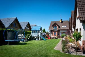 a yard with a playground in a house at Domki Oaza Spokoju in Nowęcin
