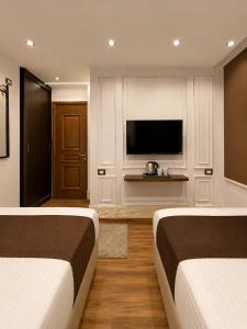 two beds in a hotel room with a television at New White Pyramids Inn in Cairo