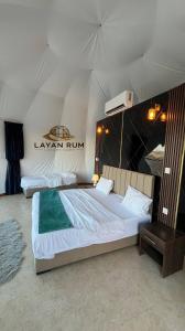 a bedroom with two beds in a tent at LAYAN RUM LUXURY CAMP & Jeep Tours in Wadi Rum