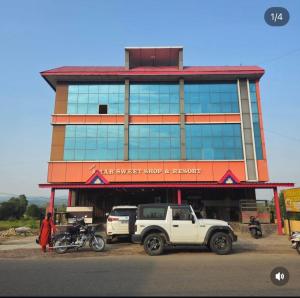a building with a truck parked in front of it at Amar Sweets and Resort in Una