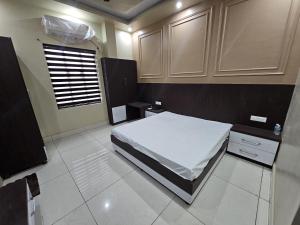 a bedroom with a white bed and a window at Amar Sweets and Resort in Una