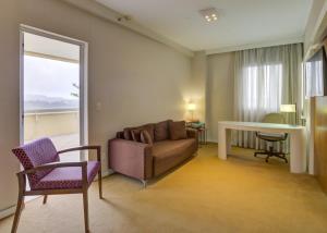 a living room with a couch and a table and a window at Quality Suites Alphaville in Barueri +66 photos