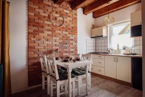 a kitchen with a white table and a brick wall at Domki Oaza Spokoju in Nowęcin