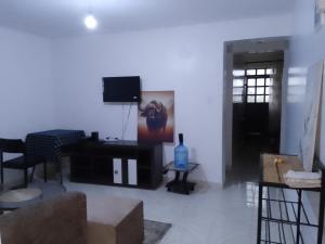 a living room with a tv on a white wall at Kiserian in Kitengela 