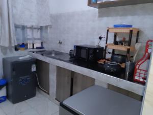 a kitchen counter with a microwave and a sink at Kiserian in Kitengela  +4 photos