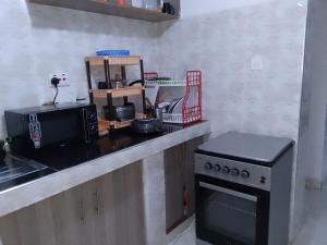 a kitchen counter with a stove and a microwave at Kiserian in Kitengela 