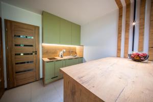 a kitchen with green cabinets and a wooden counter top at Rusnės Vėjas in Rusnė