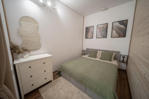 a small bedroom with a bed and a dresser at Rusnės Vėjas in Rusnė