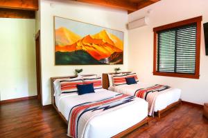 two beds in a room with a painting on the wall at Elysian at Mount Baker in Glacier