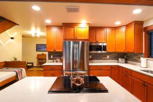 a kitchen with wooden cabinets and a stainless steel refrigerator at Elysian at Mount Baker in Glacier