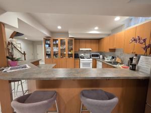 a kitchen with a large counter with two bar stools at Executive Room in North York Centre in Toronto