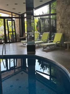 a swimming pool in a hotel with lounge chairs at Alpine Lodge Chalet in Bansko in Bansko