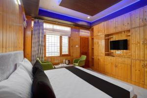 a bedroom with a large bed and a tv at Shiwalik Hills in Shimla