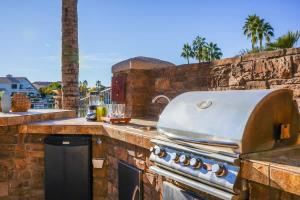 an outdoor kitchen with a grill on a stone counter at Lakeside Luxury Val Vista in Gilbert