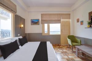 a bedroom with a bed and a table and a window at Shiwalik Hills in Shimla +42 photos