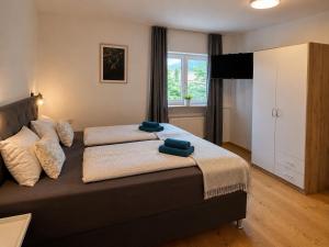a bedroom with a bed with two towels on it at Ferienwohnung Wendelstein in Kiefersfelden