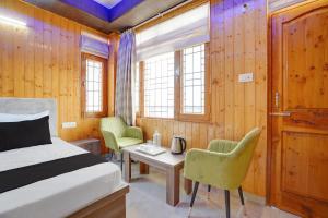 a bedroom with a bed and a table and chairs at Shiwalik Hills in Shimla