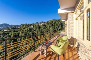 a balcony with chairs and a table and a view at Shiwalik Hills in Shimla