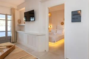 a bedroom with a bed and a tv on a wall at Sea View Kerame in Evdilos +95 photos