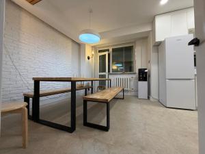 a table and a bench in a room with a refrigerator at Mickey central 2 hostel in Ulaanbaatar