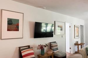 a living room with a flat screen tv on a wall at Steps to Beach & Lake Michigan! Family Retreat in Turner Shores