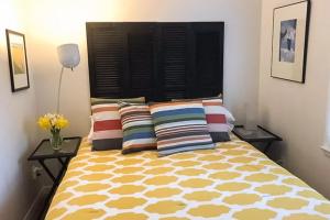 a bedroom with a bed with colorful pillows at Steps to Beach & Lake Michigan! Family Retreat in Turner Shores