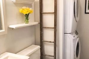 a bathroom with a refrigerator and a vase of yellow flowers at Steps to Beach & Lake Michigan! Family Retreat in Turner Shores +15 photos