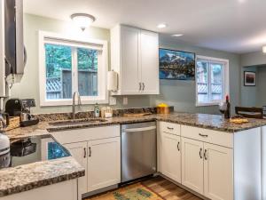 a kitchen with white cabinets and granite counter tops at Kulshan Cabin in Glacier
