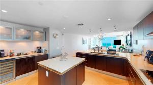 a kitchen with wooden cabinets and a white counter top at Jade Beach Escape in Sunny Isles Beach