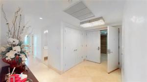 a hallway with white walls and a vase of flowers at Jade Beach Escape in Sunny Isles Beach