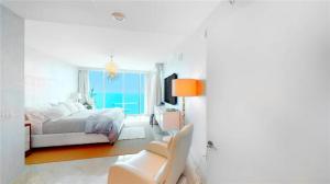 a white bedroom with a bed and a window at Jade Beach Escape in Sunny Isles Beach