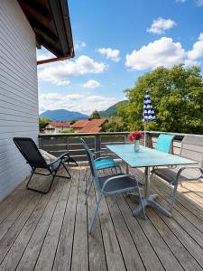 a patio with a table and chairs on a deck at Ferienwohnung Wendelstein in Kiefersfelden
