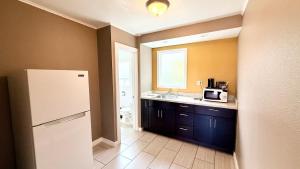 a kitchen with a white refrigerator and a sink at Capitol Hill Motel in Portland