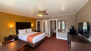 a hotel room with a bed and a flat screen tv at Capitol Hill Motel in Portland