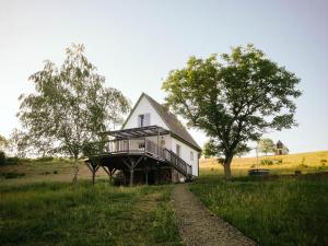 a house with a wrap around deck on a field at Cserháti Házikó in Alsótold
