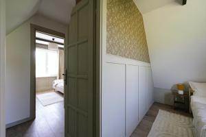 a bedroom with a door leading into a room with a bed at Cserháti Házikó in Alsótold +20 photos