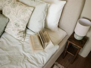 two books are laying on a bed with a pillow at Cserháti Házikó in Alsótold