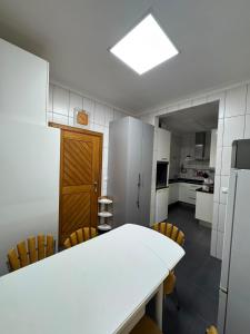 a kitchen with a table and chairs and a refrigerator at Casa cidade e piscina in Coimbra