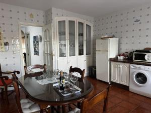 a kitchen with a dining room table and a refrigerator at Casa Los Barberos in Valle de Abdalagís
