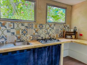 a kitchen with a sink and a stove and two windows at Loft Bugambilia en Casa Viva Merida in Techoh