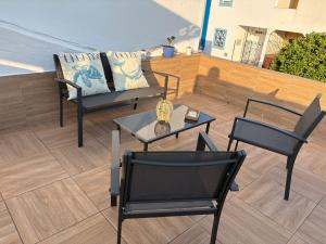 a patio with two chairs and a table and a couch at Palmera in Isla del Moral