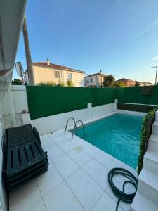 a small swimming pool with a bench next to it at Casa cidade e piscina in Coimbra
