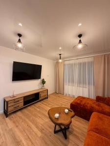 a living room with a flat screen tv and a couch at Livia Residence II in Constanţa