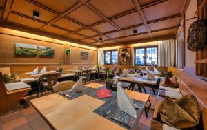 a restaurant with tables and chairs in a room at Ellgass Allgäu Hotel in Eglofs