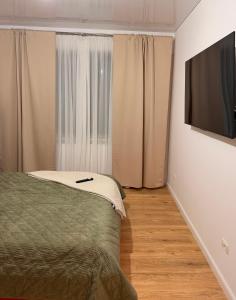 a bedroom with a bed and a flat screen tv at Livia Residence II in Constanţa