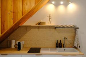 a kitchen with a sink and a shelf under a staircase at La VilLaye in Laye