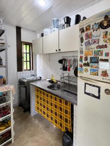 a kitchen with a sink and a refrigerator at Casa da Mata Madalena in Angra dos Reis